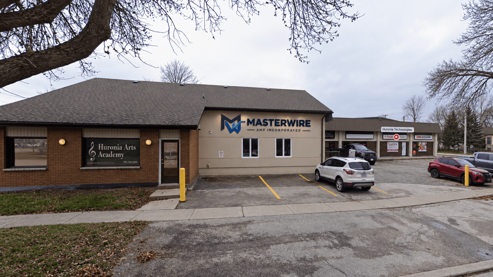 Exterior of a commercial building featuring Huronia Arts Academy and Masterwire Amp Incorporated signs.